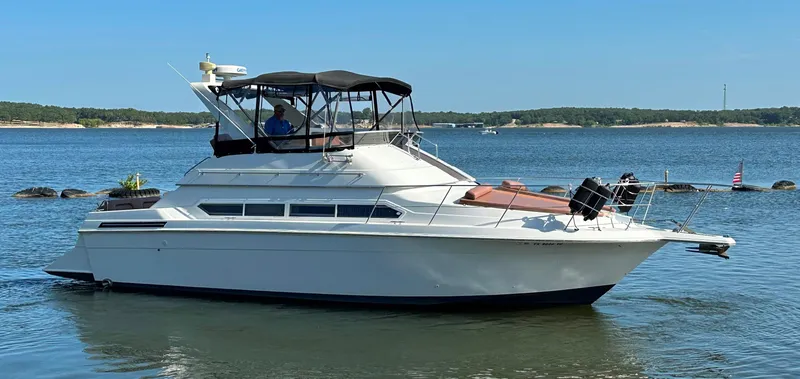 Slide: The Image of 1996 Carver 38 Santego yacht on a serene lake with clear blue skies. - 10