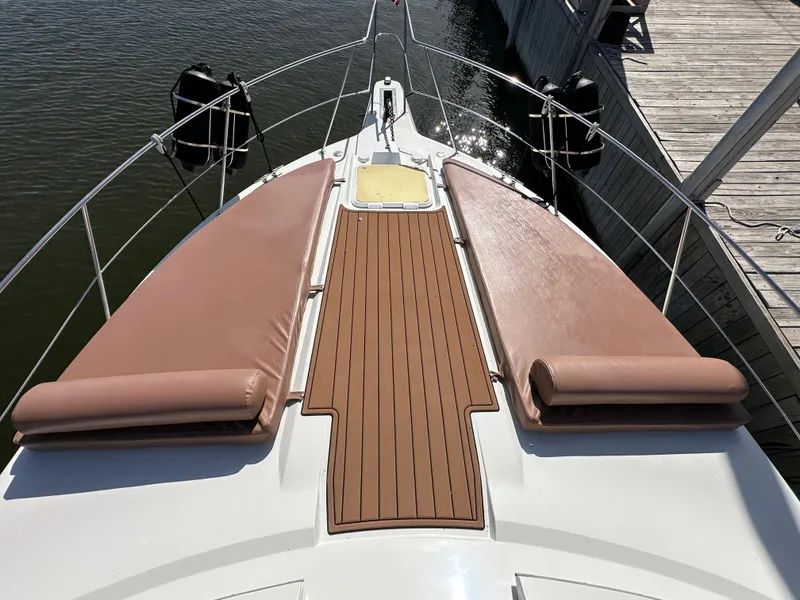 Slide: The Image of 1996 Carver 38 Santego yacht bow with cushioned sun pads and wooden deck. - 19