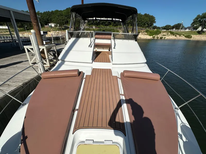 Slide: The Image of 1996 Carver 38 Santego yacht with sunbathing deck, docked by a serene waterfront. - 21