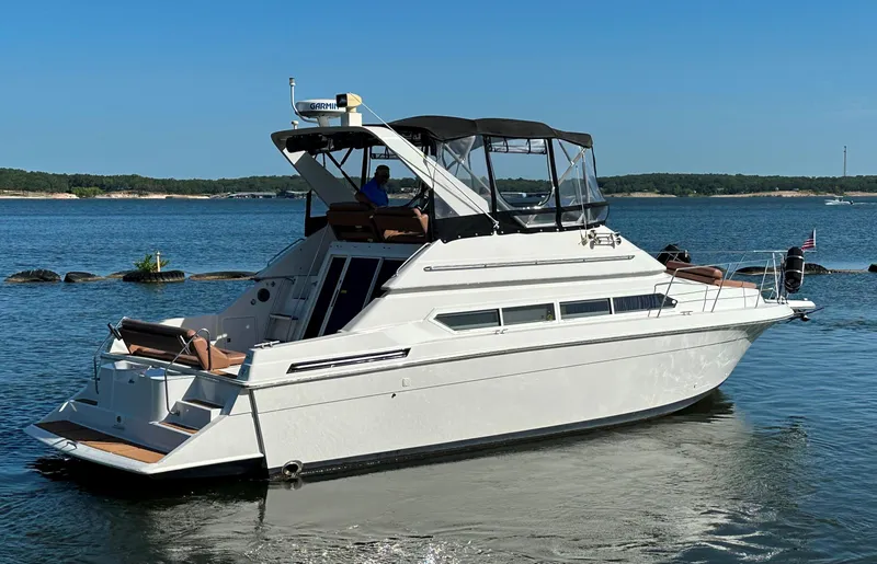 Slide: The Image of 1996 Carver 38 Santego yacht on calm water, featuring sleek design and spacious deck. - 8