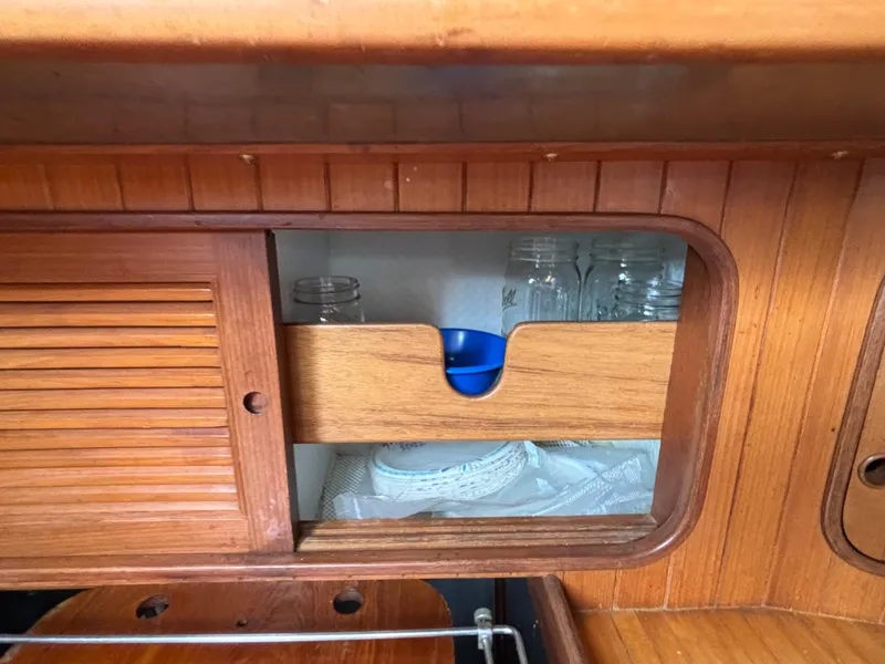 Slide: The Image of Wooden cabinet with sliding doors on a 1987 Ta Shing Tashiba 36 yacht, storing glass jars and bowls. - 33