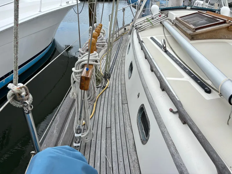 Slide: The Image of 1987 Ta Shing Tashiba 36 sailboat deck with ropes and wooden details at a marina. - 7