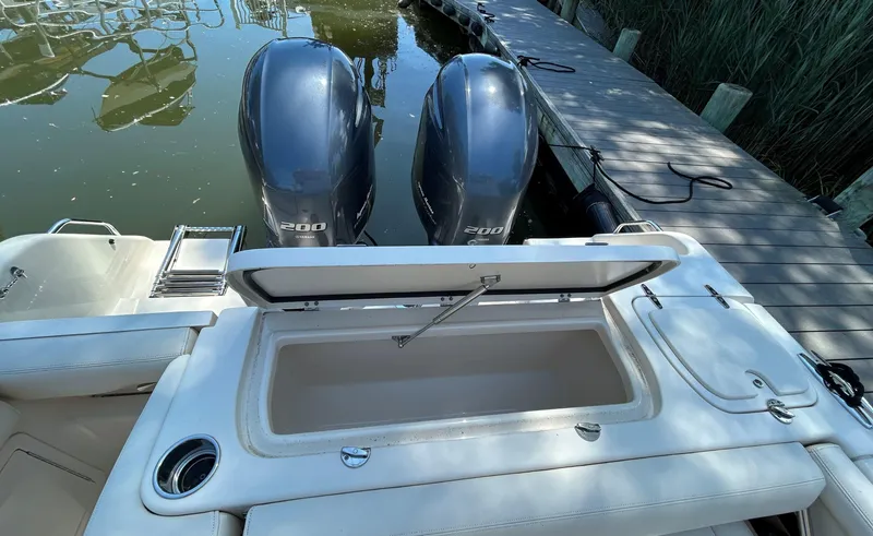 Slide: The Image of 2016 Grady-White Freedom 275 boat with dual 200 horsepower engines docked by a pier. - 10