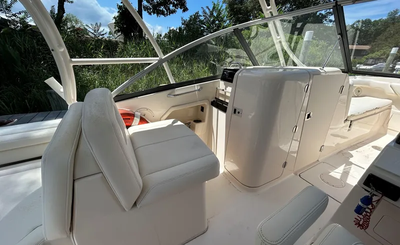 Slide: The Image of Interior of a 2016 Grady-White Freedom 275 boat with white seating and console. - 12