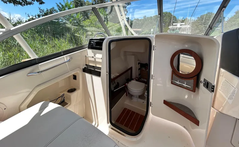 Slide: The Image of 2016 Grady-White Freedom 275 boat interior with open cabin door and visible toilet. - 13