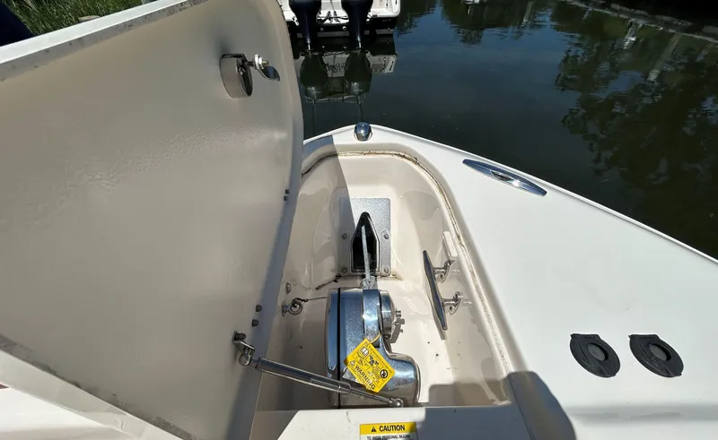 Slide: The Image of 2016 Grady-White Freedom 275 boat anchor compartment open, showing winch and storage. - 18