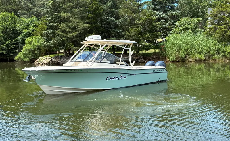 Slide: The Image of 2016 Grady-White Freedom 275 boat on a serene lake surrounded by lush greenery. - 4