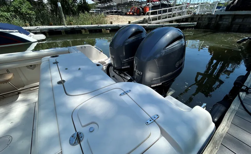 Slide: The Image of 2016 Grady-White Freedom 275 boat with dual Yamaha outboard engines docked by the water. - 7