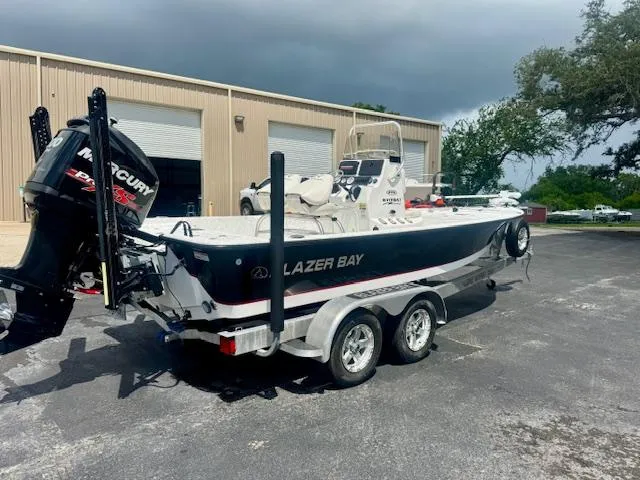 Slide: The Image of 2017 Blazer Bay 2170 boat on trailer, parked outside a warehouse. - 2