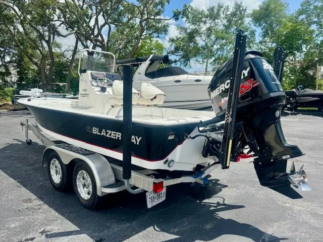 Slide: The Image of 2017 Blazer Bay 2170 boat with Mercury engine on a trailer in a sunny outdoor setting. - 4
