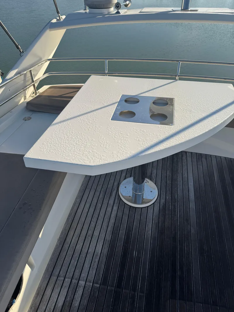 Slide: The Image of Flybridge table on 2015 Prestige 450 Fly yacht, overlooking calm water. - 12