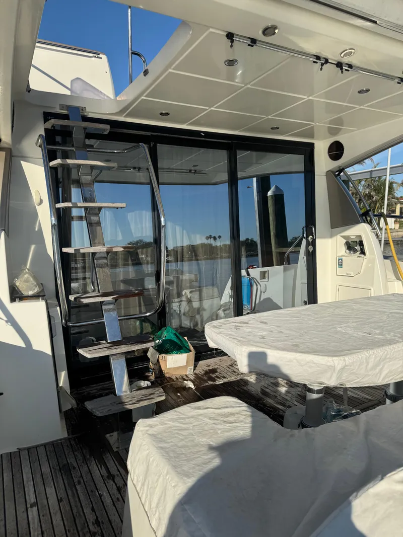 Slide: The Image of Prestige 450 Fly 2015 yacht deck with covered table and metal staircase. - 16