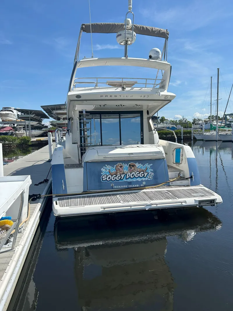 Slide: The Image of 2015 Prestige 450 Fly yacht docked, rear view with "Soggy Doggy II" nameplate. - 3