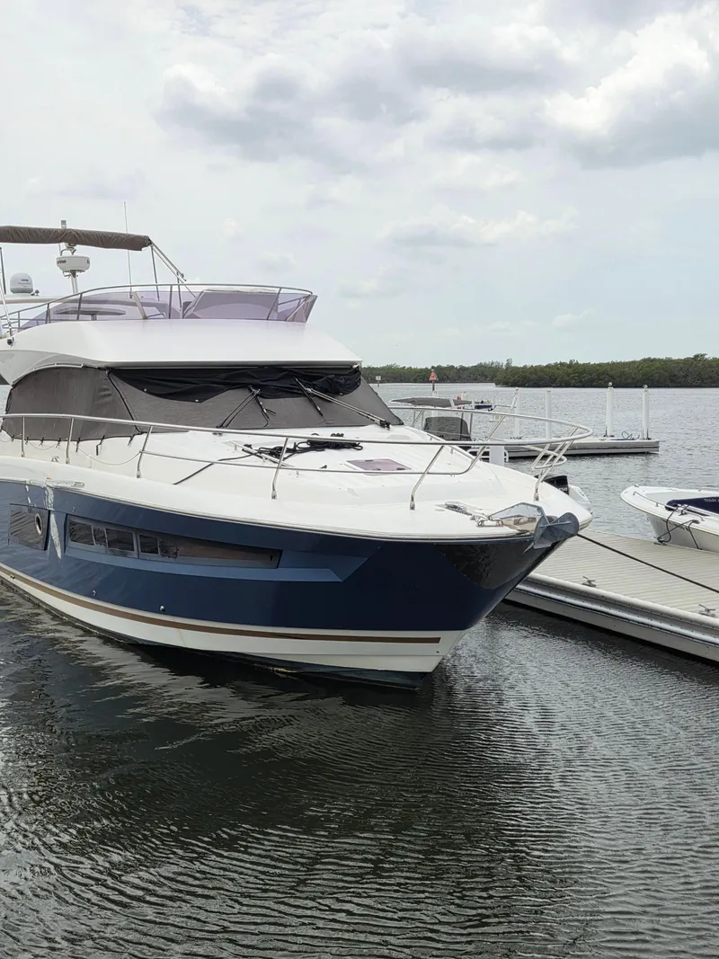 Slide: The Image of 2015 Prestige 450 Fly yacht docked at marina, overcast sky. - 6