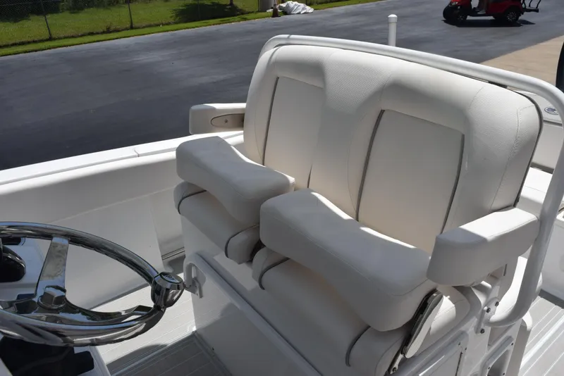 Slide: The Image of 2023 Sea Hunt Ultra 234 boat with plush white seating and steering wheel. - 10