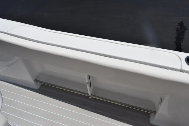 Slide: The Image of 2023 Sea Hunt Ultra 234 boat interior with sleek white seating and storage compartment. - 20