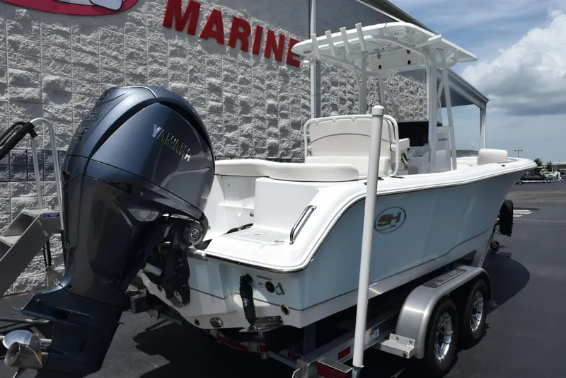 Slide: The Image of 2023 Sea Hunt Ultra 234 boat with Yamaha engine on trailer, parked outside marine store. - 4