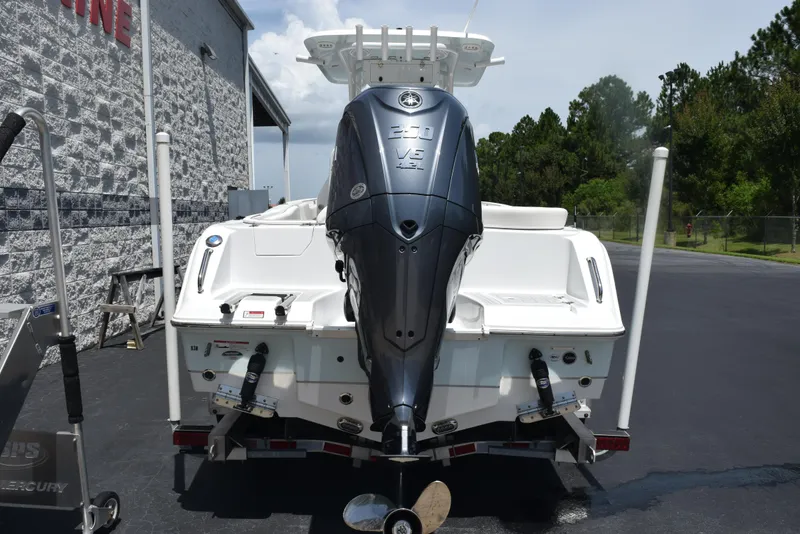 Slide: The Image of 2023 Sea Hunt Ultra 234 boat with powerful outboard motor, parked outdoors. - 5