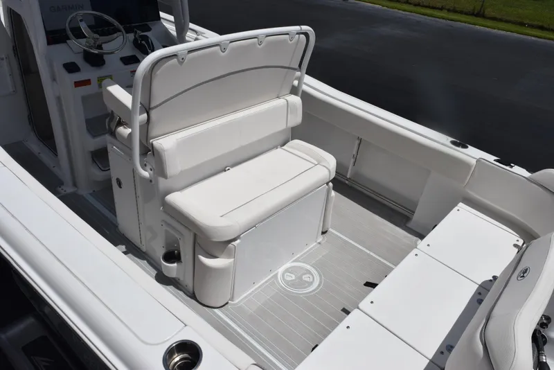 Slide: The Image of 2023 Sea Hunt Ultra 234 boat interior with white seating and steering console. - 7