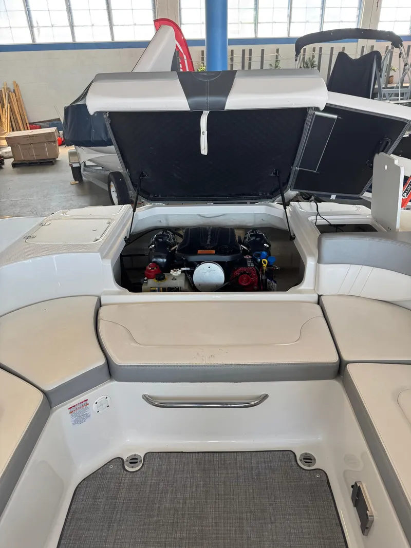 Slide: The Image of 2021 Chaparral 23ssi boat engine compartment with open hatch in showroom. - 14
