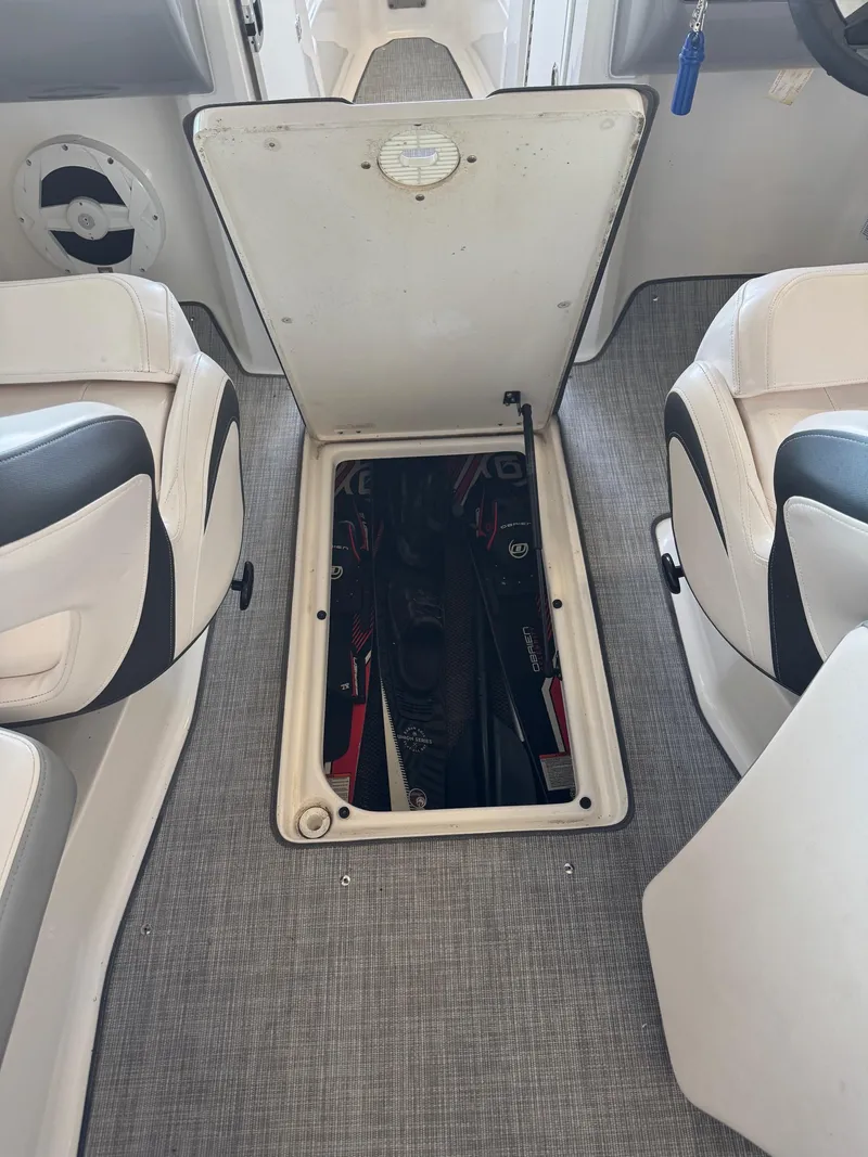 Slide: The Image of 2021 Chaparral 23ssi boat interior with open storage compartment between seats. - 15