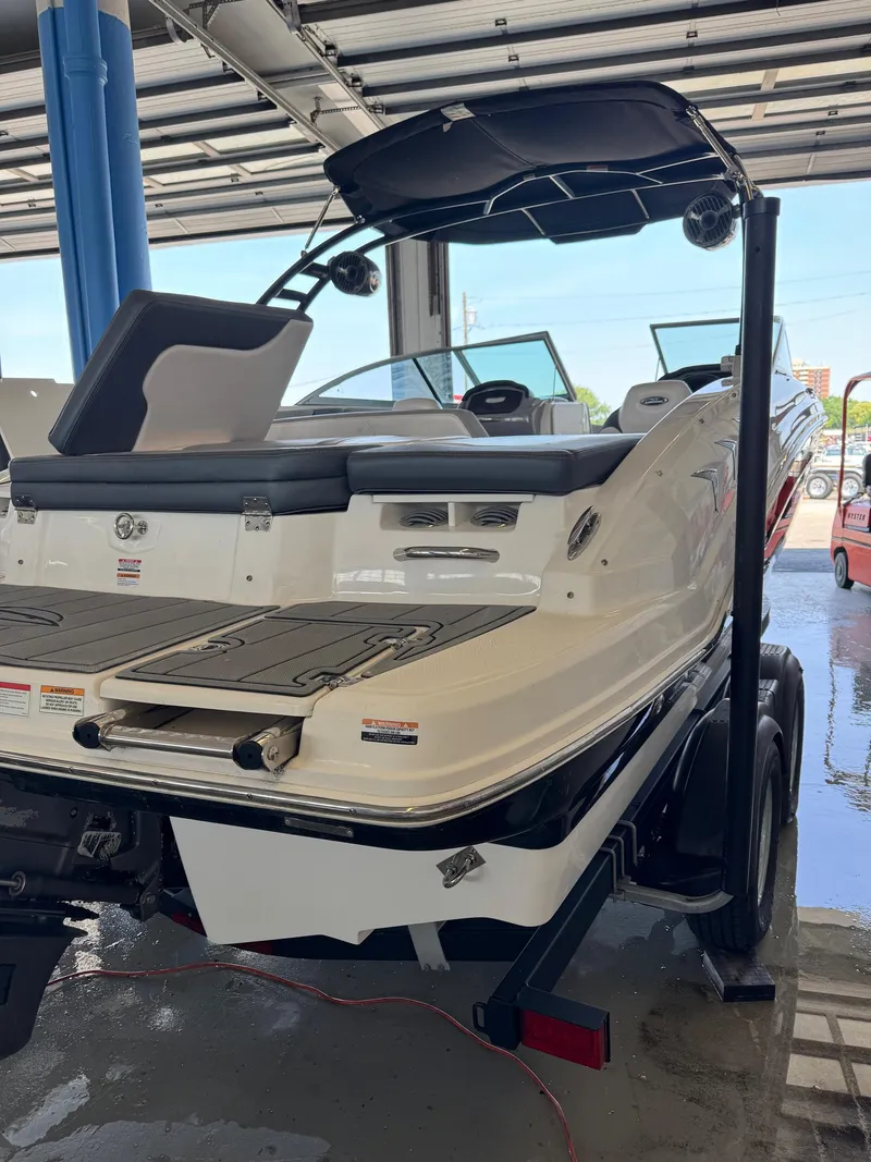 Slide: The Image of 2021 Chaparral 23ssi boat in showroom, rear view with swim platform and seating. - 5