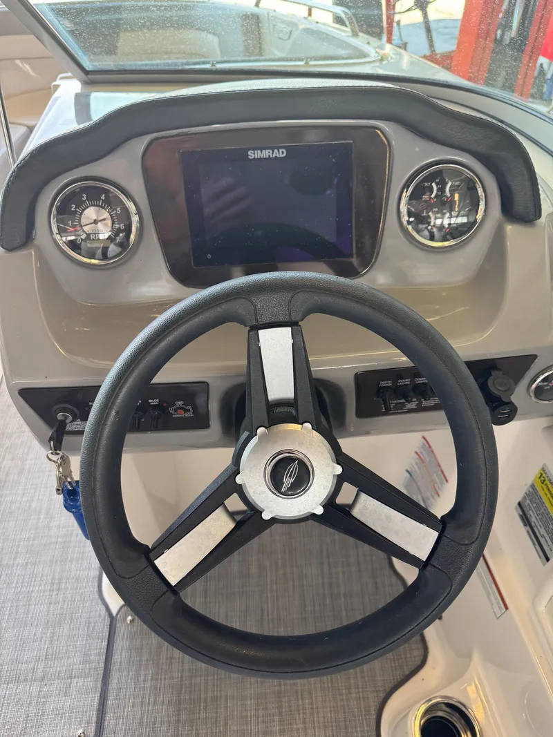 Slide: The Image of 2021 Chaparral 23ssi boat dashboard with steering wheel and Simrad display. - 6