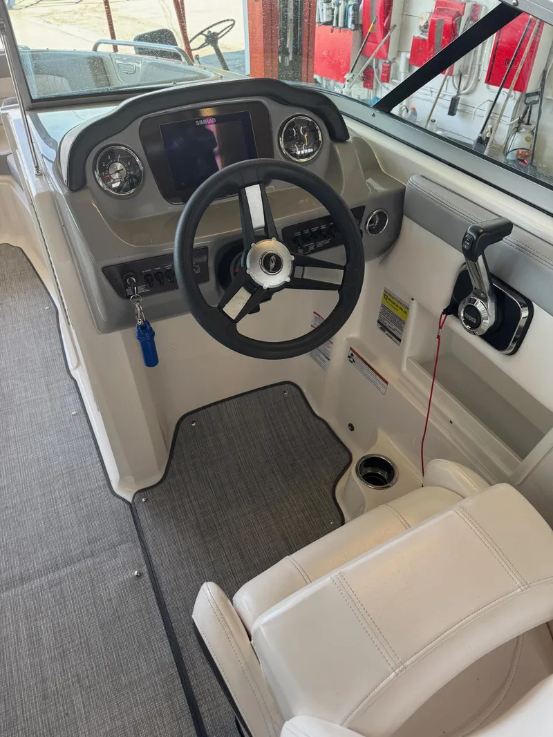 Slide: The Image of 2021 Chaparral 23ssi boat cockpit with steering wheel and control panel. - 7