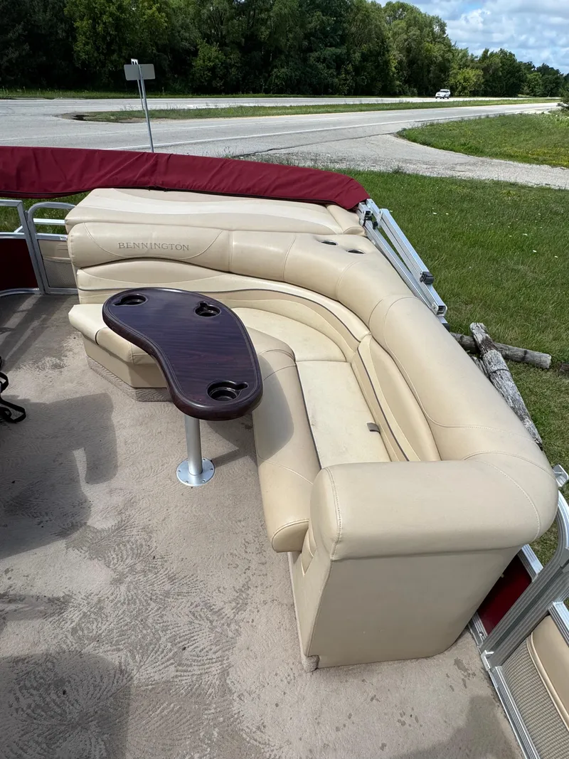 Slide: The Image of 2008 Bennington 2275RLi boat interior with beige seating and a wooden table. - 11