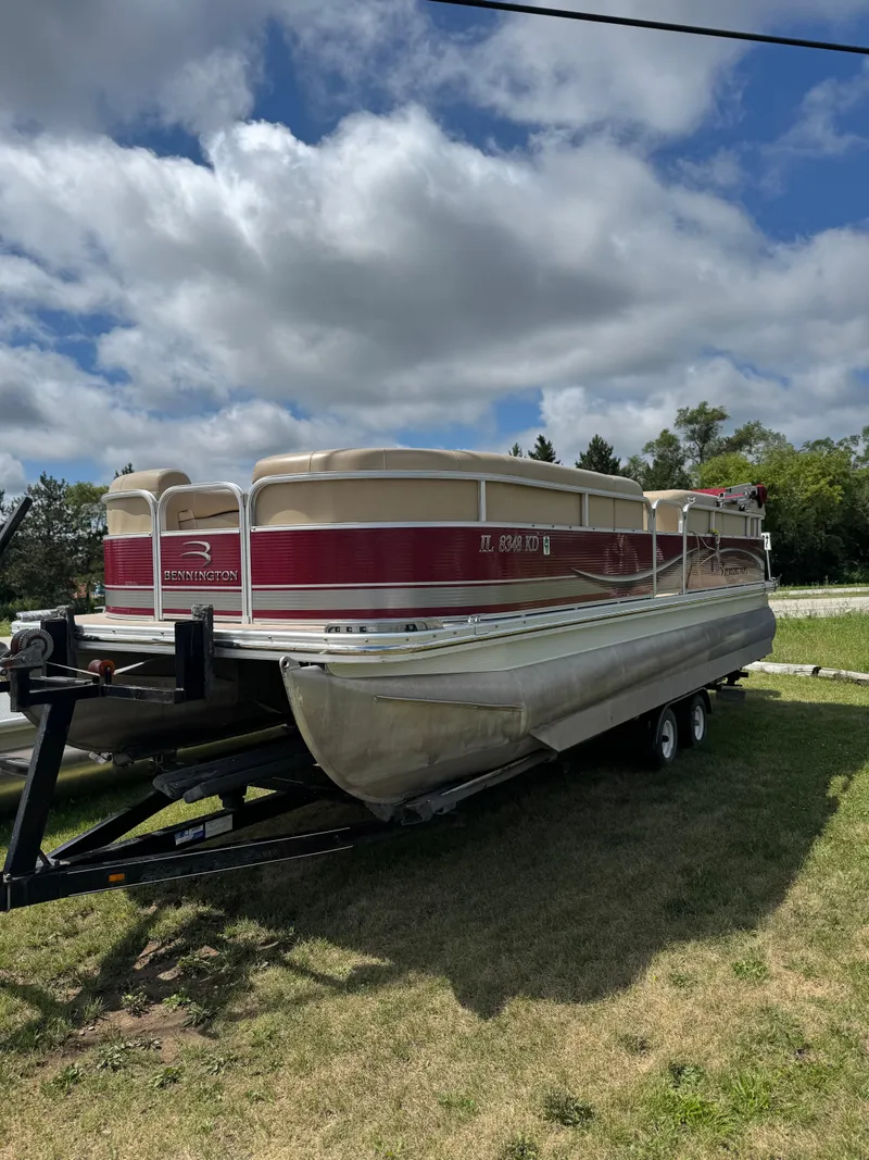 Slide: The Image of 2008 Bennington 2275RLi pontoon boat on trailer, parked on grass under cloudy sky. - 3