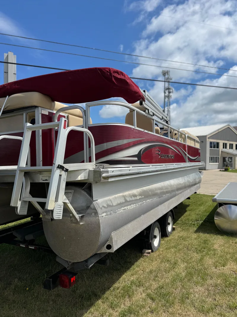 Slide: The Image of 2008 Bennington 2275RLi pontoon boat on trailer, red and silver design, parked on grass. - 6