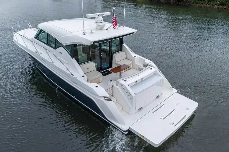 Slide: The Image of 2020 Tiara Yachts C44 Coupe cruising on calm waters, rear view. - 10