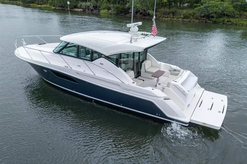Slide: The Image of 2020 Tiara Yachts C44 Coupe cruising on a serene waterway. - 11