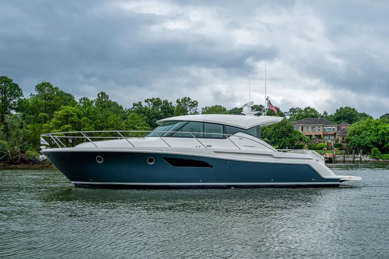 Slide: The Image of 2020 Tiara Yachts C44 Coupe on a serene waterway, surrounded by lush greenery. - 13