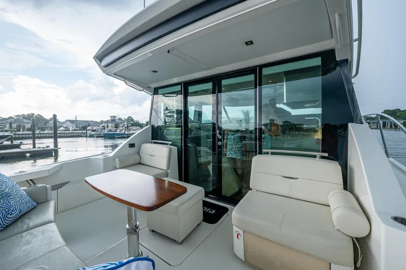 Slide: The Image of 2020 Tiara Yachts C44 Coupe, elegant deck seating with marina view. - 29