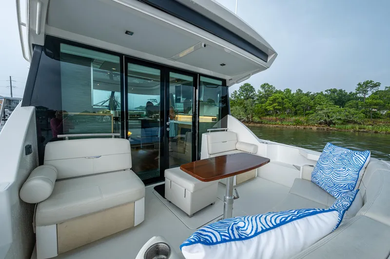 Slide: The Image of 2020 Tiara Yachts C44 Coupe, elegant outdoor seating with scenic water view. - 33