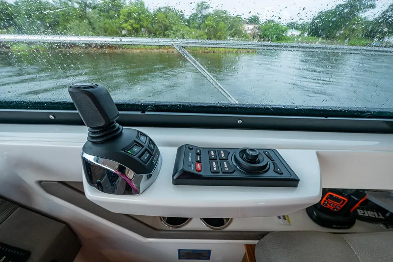 Slide: The Image of Control panel of 2020 Tiara Yachts C44 Coupe with joystick and buttons, rainy window view. - 39