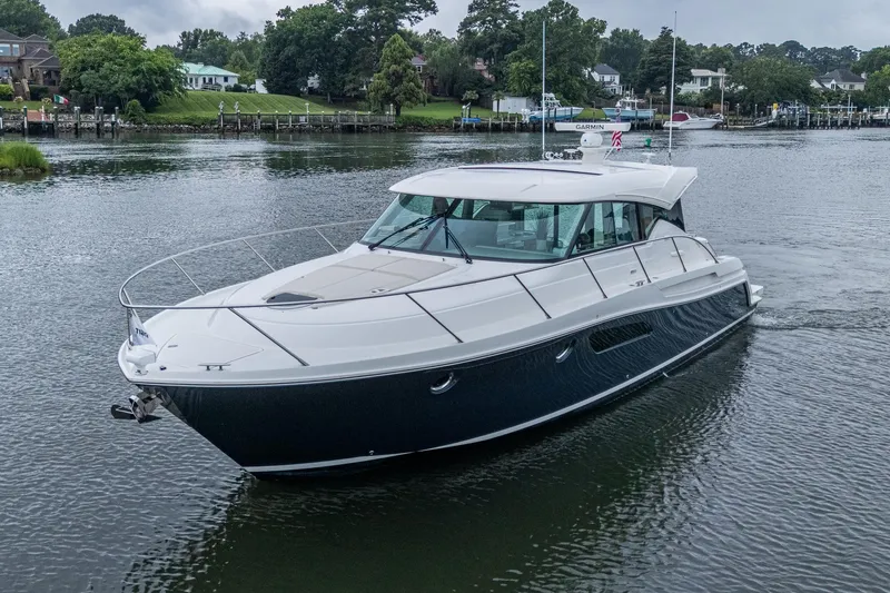 Slide: The Image of 2020 Tiara Yachts C44 Coupe cruising on a serene waterway. - 4
