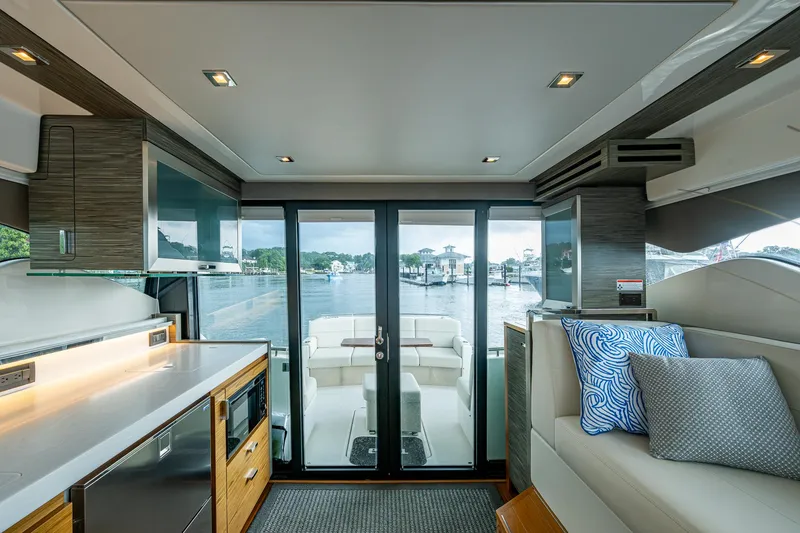 Slide: The Image of Interior of 2020 Tiara Yachts C44 Coupe, featuring modern kitchen and seating with waterfront view. - 43
