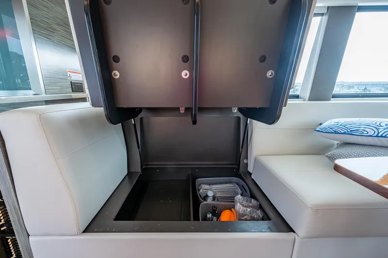 Slide: The Image of 2020 Tiara Yachts C44 Coupe interior storage compartment with organized items. - 44