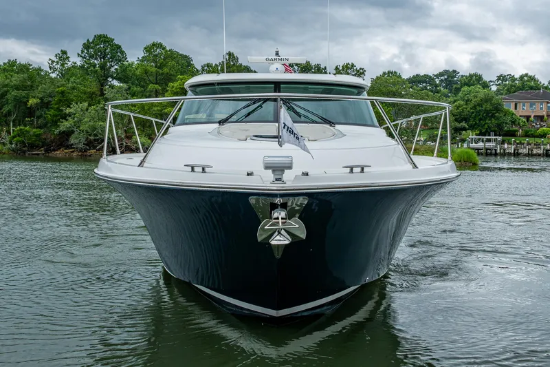Slide: The Image of 2020 Tiara Yachts C44 Coupe on water, front view with lush greenery background. - 5