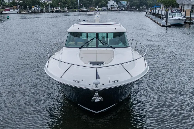 Slide: The Image of 2020 Tiara Yachts C44 Coupe on water, front view, docked in marina. - 6