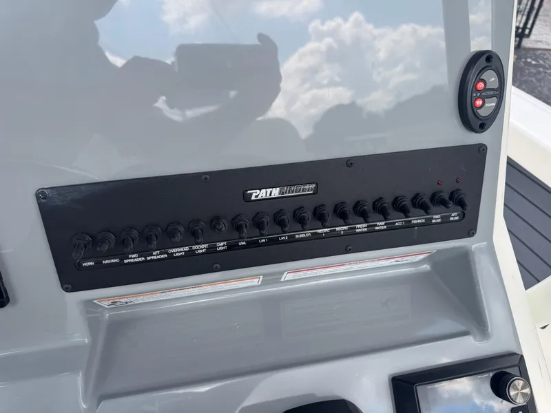 Slide: The Image of Control panel of 2025 Pathfinder 2400 TRS boat with various switches and controls. - 15