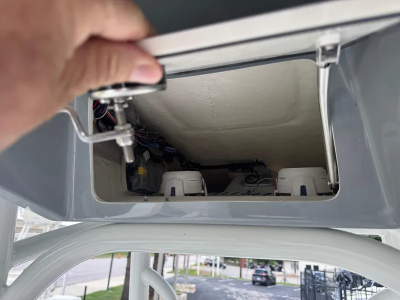 Slide: The Image of Open compartment of 2025 Pathfinder 2400 TRS boat, showing interior wiring and components. - 19