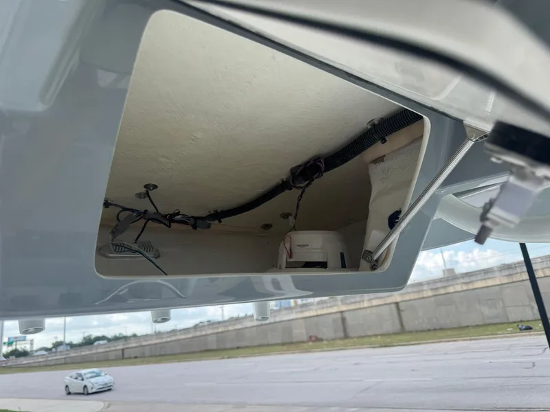 Slide: The Image of Open compartment of 2025 Pathfinder 2400 TRS boat showing internal wiring and components. - 21