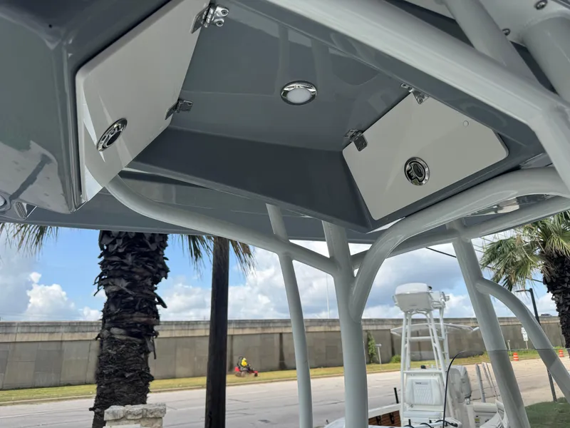 Slide: The Image of 2025 Pathfinder 2400 TRS boat T-top storage compartments under a clear blue sky. - 24