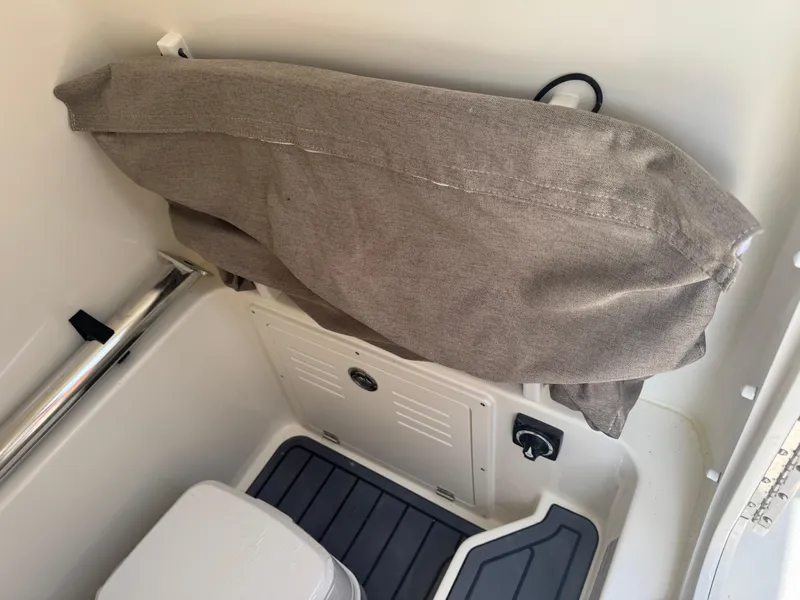 Slide: The Image of Interior of 2025 Pathfinder 2400 TRS boat with storage compartment and cushioned seat. - 28