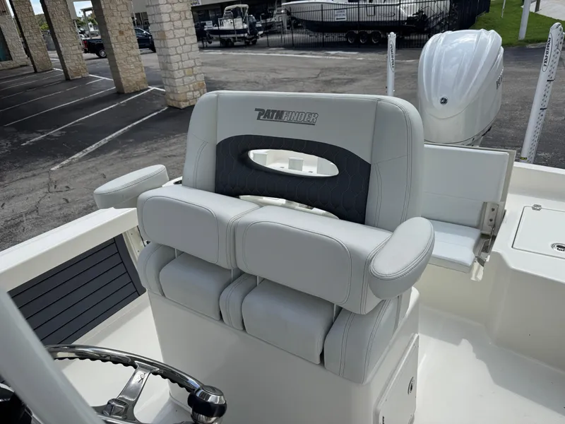 Slide: The Image of 2025 Pathfinder 2400 TRS boat interior with cushioned seating and steering wheel. - 36