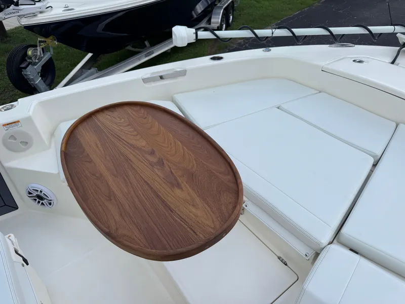 Slide: The Image of 2025 Pathfinder 2400 TRS boat interior with wooden table and white seating. - 46
