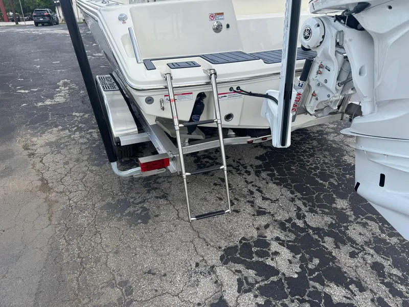 Slide: The Image of 2025 Pathfinder 2400 TRS boat rear view with ladder and motor on cracked pavement. - 5